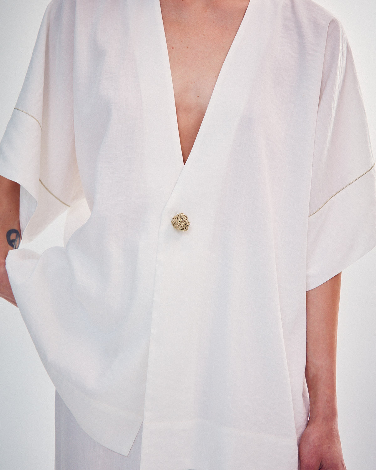Shirt with a knitted gold button